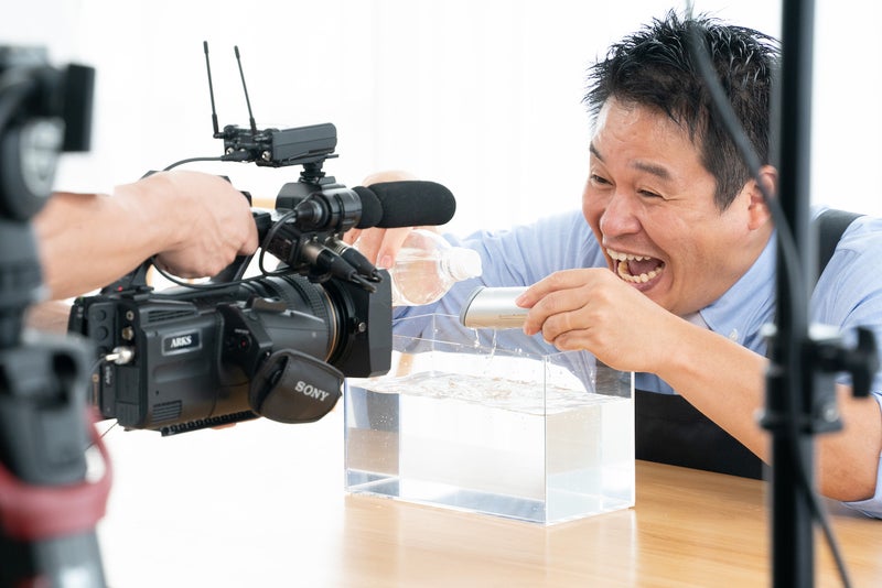 完全防水仕様の摩擦レス洗顔ブラシに水をかけるレジェンド松下さんの写真