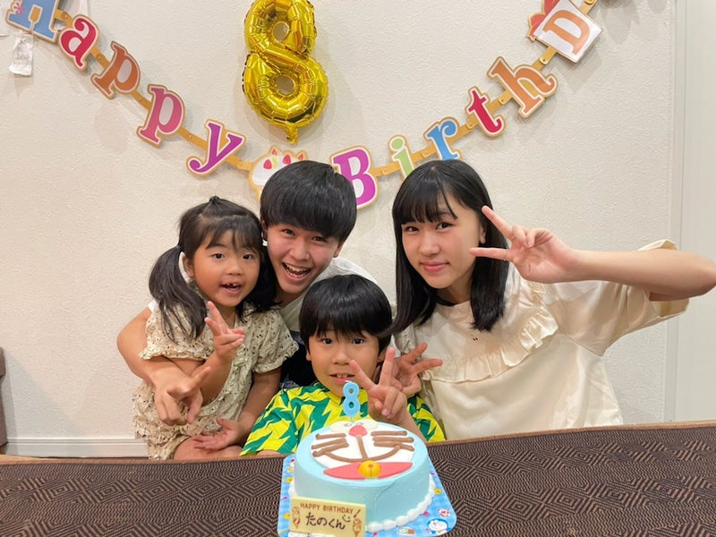 【写真】弟の楽くんを中心に4人兄弟が仲良くピースをしている。目の前にはドラえもんのケーキ。背景にはHappy Birthdayと8の飾り付け。