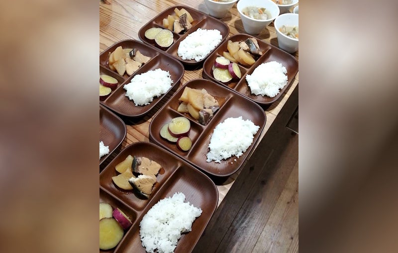 ぶり大根、さつま芋の甘煮、ごはんのプレートが並んだ食卓の写真