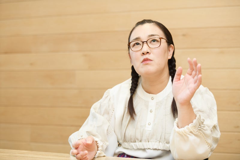 左手をあげて考えながら話す白鳥久美子さんの写真