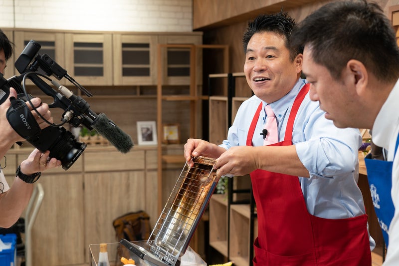 油まみれでさわりたくないほど汚れた魚焼きグリルがピカピカになる実演をするレジェンド松下さんの写真