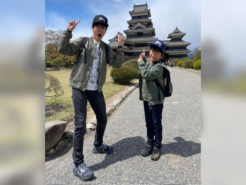 【写真】バックの松本城を指差しポーズを決める福くんと弟の楽くん。