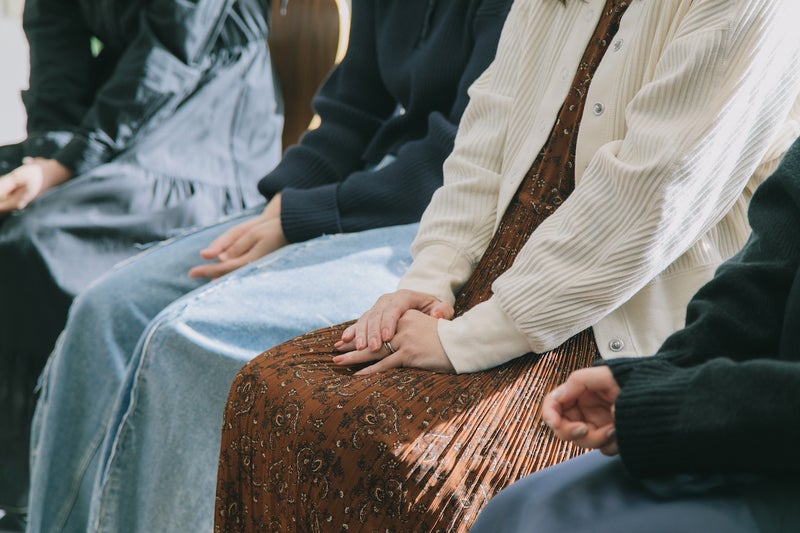 【写真】膝に手を置いて椅子に座っている4人の女性