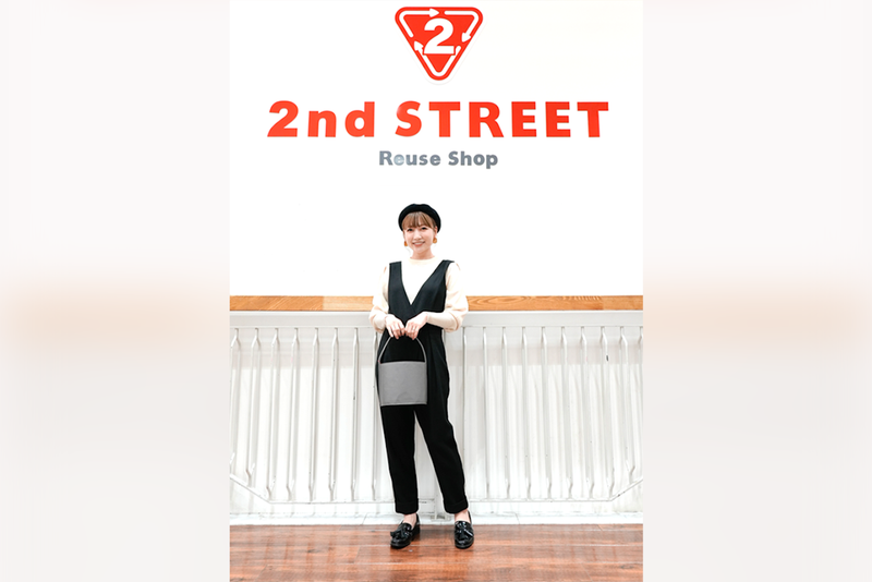 「2nd STREET」ロゴの前でポーズを決める桃さんの写真