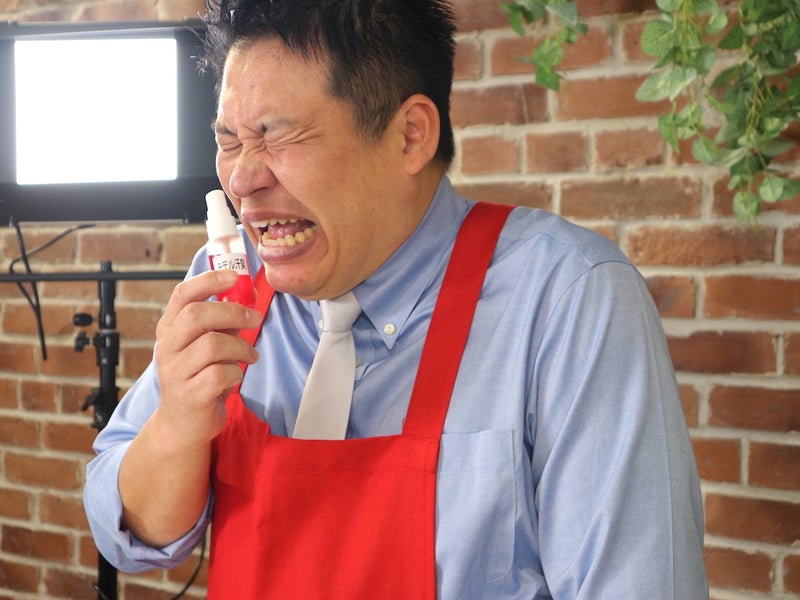 モデル汗臭ボトルを嗅いで顔をしかめるレジェンド松下さんの写真