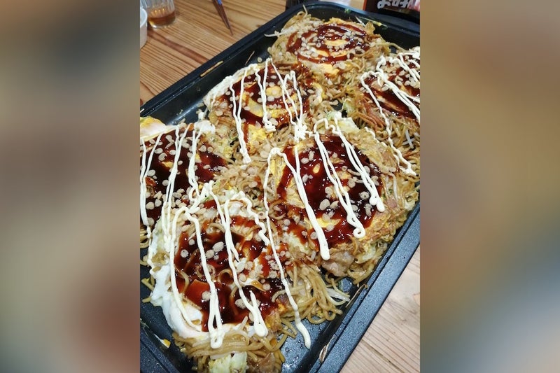 お好み焼きが乗ったホットプレートの写真